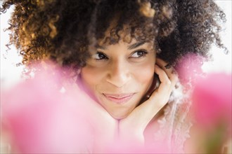 Mixed race woman resting chin in hands