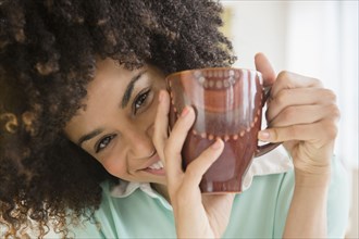 Mixed race woman drinking cup of coffee