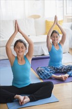 Caucasian twin sisters practicing yoga