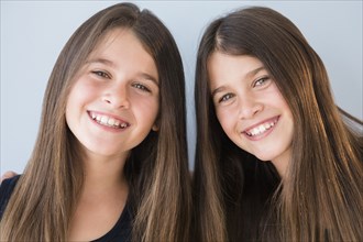 Caucasian twin sisters smiling