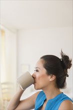 Chinese woman drinking cup of coffee