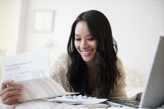 Chinese woman paying bills on laptop