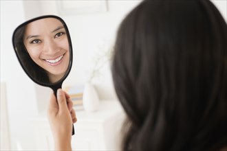 Chinese woman admiring herself in mirror