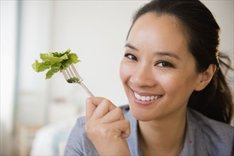 Chinese woman eating salad