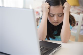 Frustrated girl using laptop