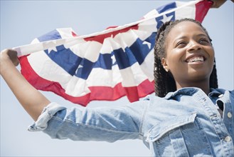 Black woman carrying American flag banner
