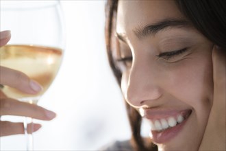 Hispanic woman holding glass of wine