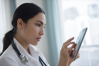 Hispanic doctor using digital tablet