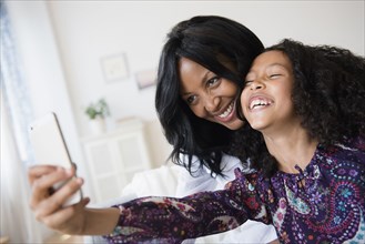 Mother and daughter taking selfie with cell phone