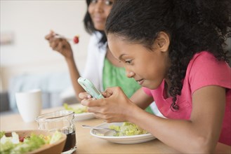 Girl using cell phone at dinner