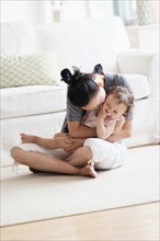 Mother and baby daughter playing in living room