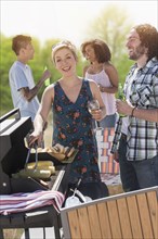 Woman serving hot dogs at barbecue