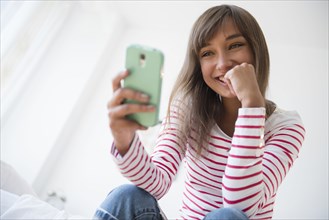 Mixed race woman taking selfie with cell phone