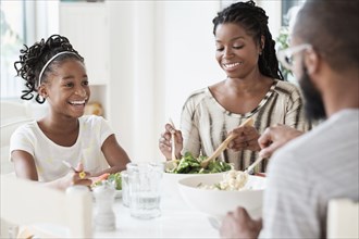 Black family eating salad at table