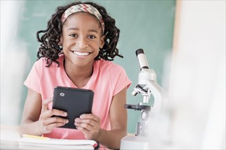 Black student using digital tablet in science class