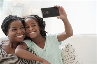 Black mother and daughter taking selfie