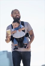 Father carrying baby son outdoors
