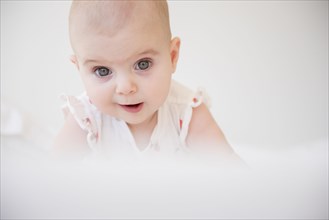 Caucasian baby girl crawling on bed
