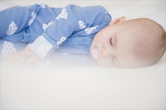 Caucasian baby girl sleeping on bed