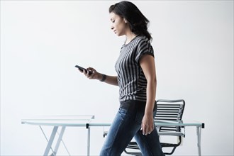 Mixed race businesswoman using cell phone