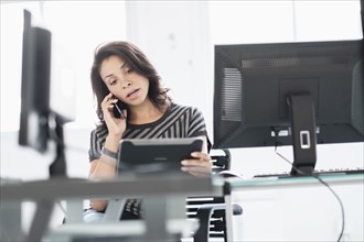 Mixed race businesswoman using digital tablet