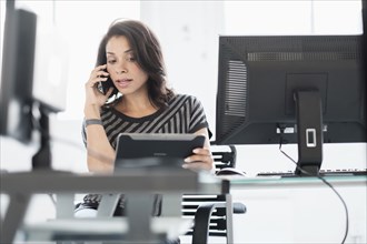 Mixed race businesswoman using digital tablet