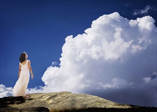Mixed race woman standing on mountaintop