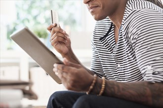 Mixed race man shopping online with digital tablet