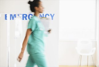 Mixed race nurse walking in hospital