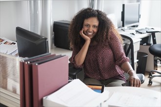 Black businesswoman smiling at office desk