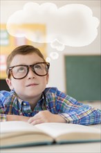 Caucasian student with thought bubble in classroom