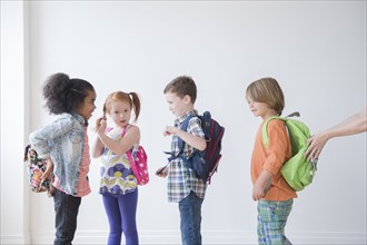 Students wearing backpacks in classroom