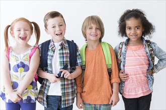 Smiling children wearing backpacks
