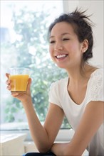 Mixed race woman drinking juice