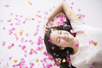 Mixed race woman playing in confetti
