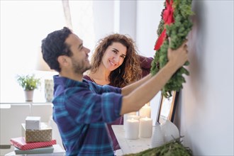 Couple hanging Christmas wreath