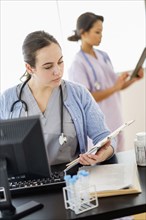 Nurse reading medical chart in hospital