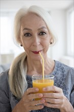 Caucasian woman drinking juice through straw