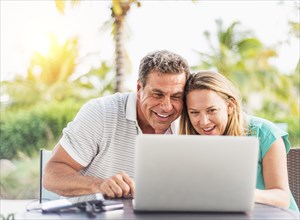 Caucasian couple using laptop outdoors