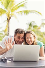 Caucasian couple video chatting on laptop outdoors