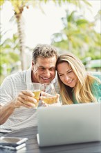 Caucasian couple video chatting on laptop outdoors