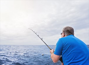 Caucasian man fishing in ocean