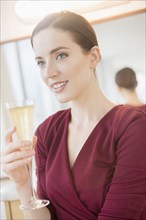 Caucasian woman drinking glass of champagne