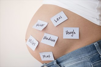 Pregnant Caucasian woman with name suggestions on belly