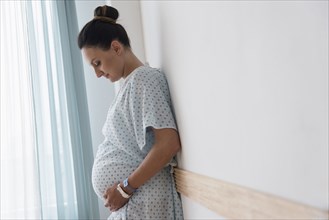Pregnant Caucasian woman wearing hospital gown