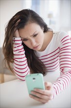 Stressed woman using cell phone
