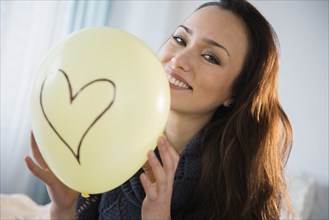 Smiling woman holding balloon
