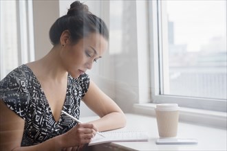 Woman writing in coffee shop