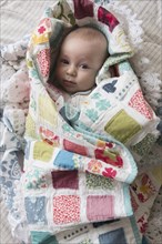 Caucasian baby wrapped in blanket