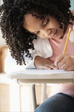 African American student writing in classroom